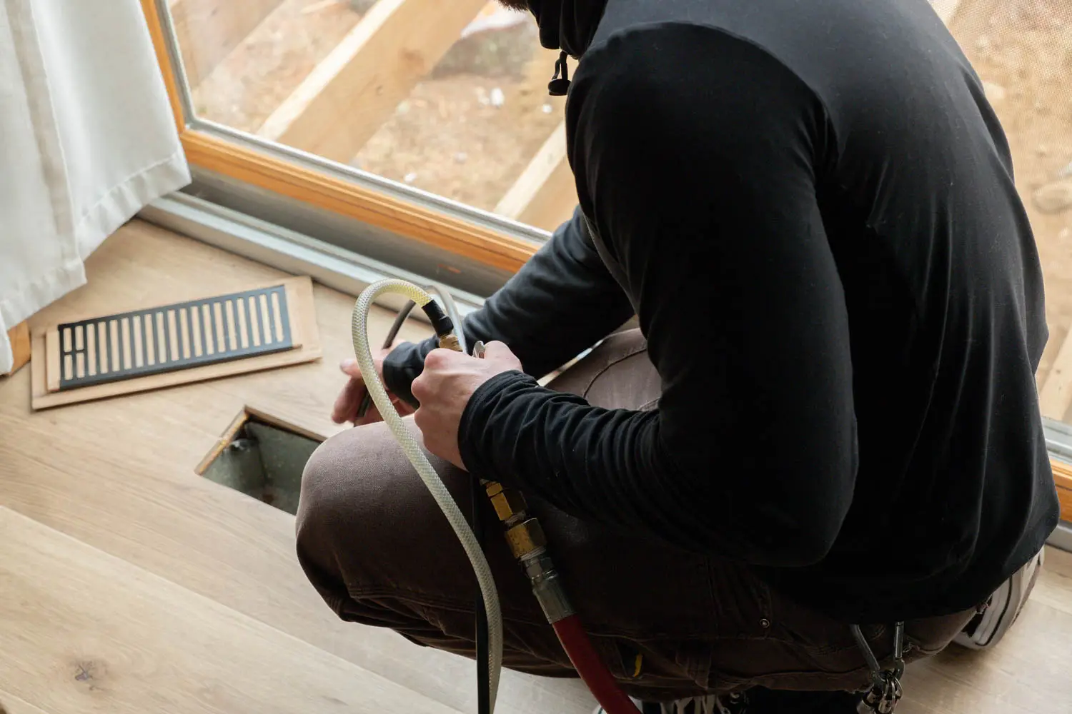 HVAC technician cleaning air ducts for improved home heating and cooling.