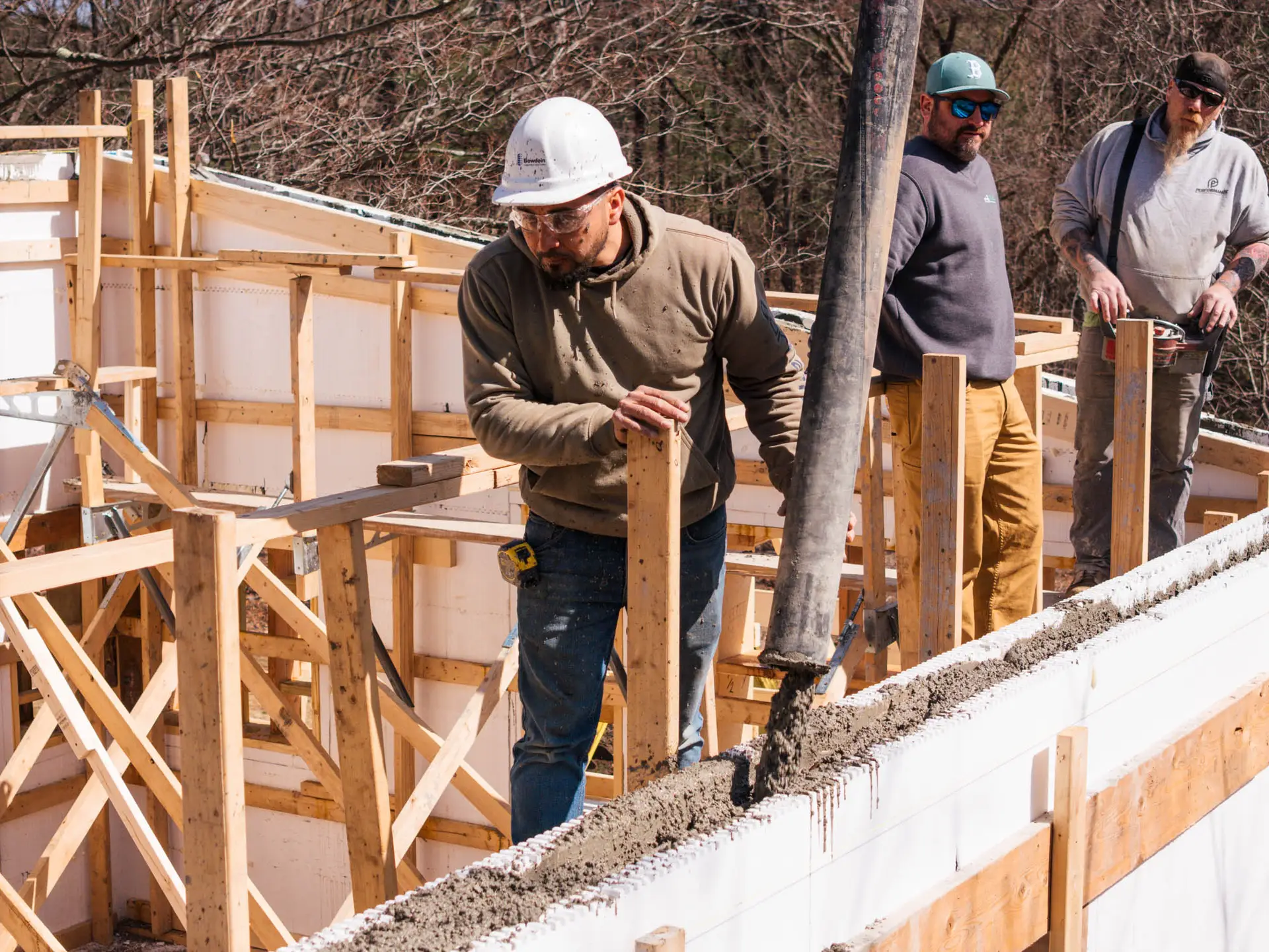 Construction crew pouring concrete foundation, authentic job site imagery for contractor marketing.