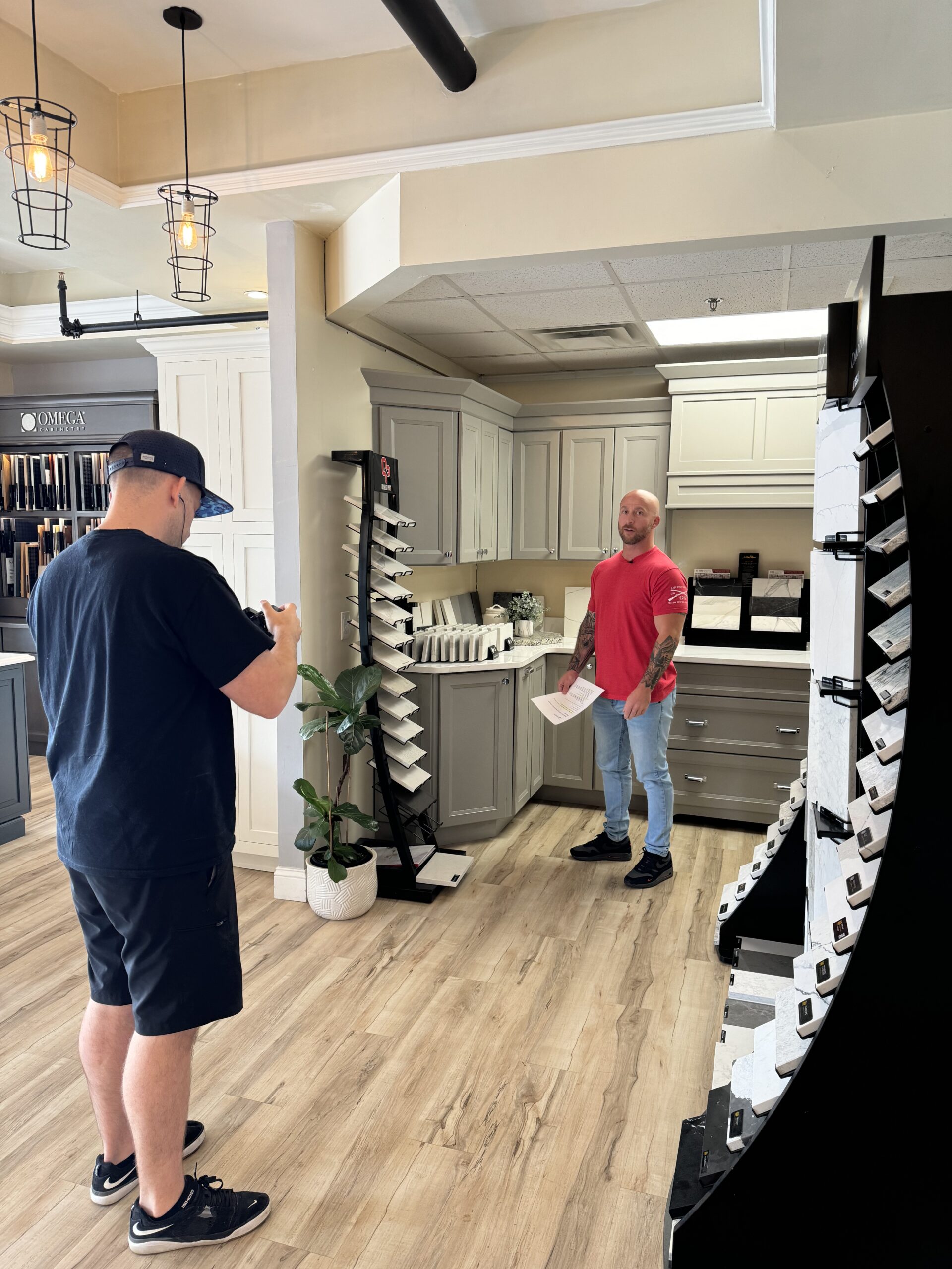 Contractor capturing social media video in kitchen design showroom with client.